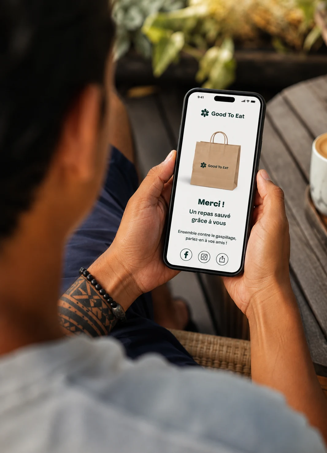 Un téléphone tenu en main, l’app ouverte sur l’écran de confirmation « Merci, un panier sauvé ».